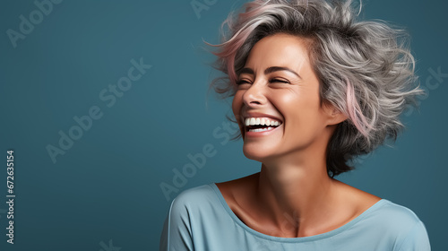Beautiful mid age woman with grey hair. Laughing and smiling. Blue background. Nature lady close up portrait. Healthy face skin care beauty, skincare cosmetics. High quality