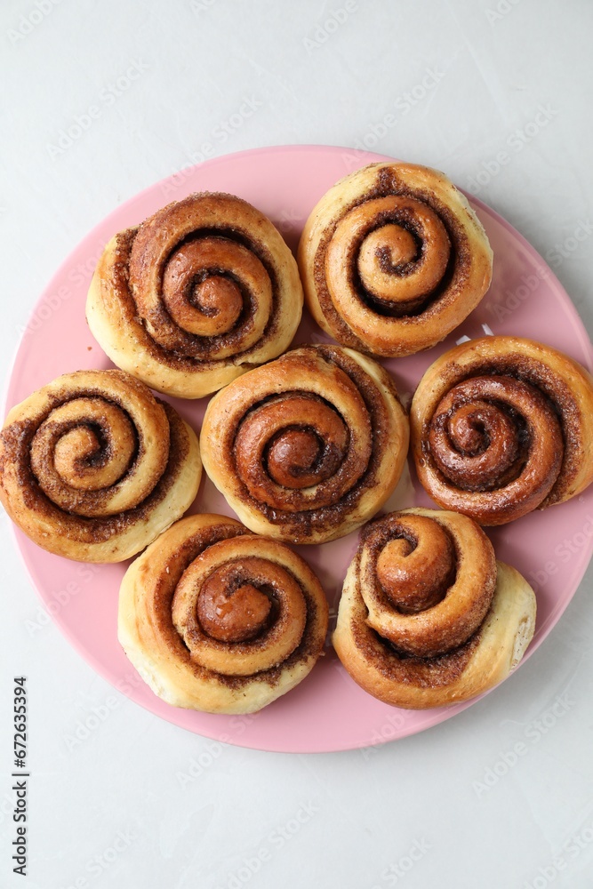 Fototapeta premium Many tasty cinnamon rolls on white table, top view