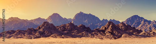 Panoramic landscape of mountain peaks in soft light on golden sunset time. Wide landscape with mountains in a desert, Africa. © Repina Valeriya
