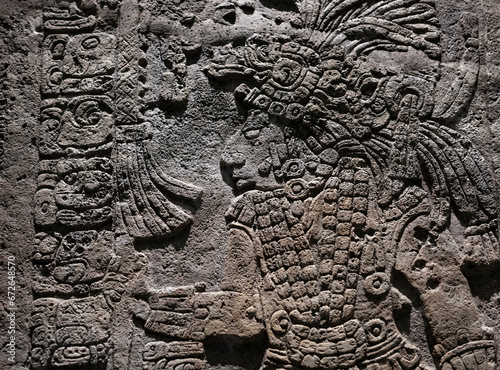Bas relief carving in a stele tombstone of a mayan ruler king with maya hieroglyph writing symbols, Mexico City, Mexico. photo