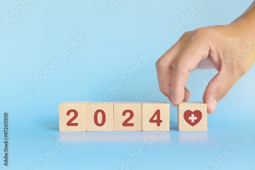 Year 2024 health goal and healthcare priority concept. Wooden blocks on blue background with icon. 