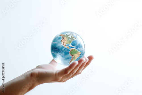Human Hand Gently Holding a Transparent Globe Against a White Background