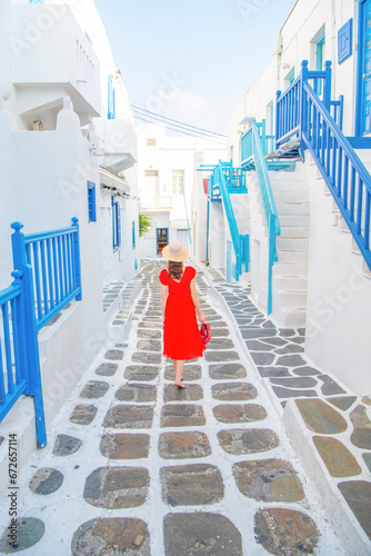 Woman in red dress at the Streets of old town Mykonos during a vacation in Greece, Little Venice Mykonos Greece © Kyrenian
