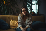 Sad young woman on sofa in living room, Brightly lit, modern living room
