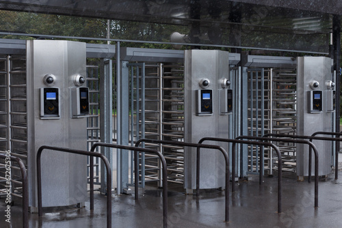 Stadium entrance area, metal access gates, ticket scanner.