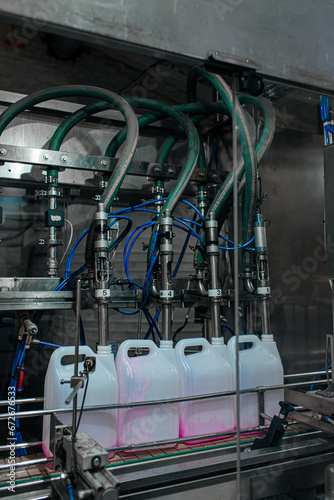 Filling bottles with water, Bottling factorys, plastic canisters, Empty plastic jerrycans moving on conveyor belt of automatic pet blow molding machine at factory
