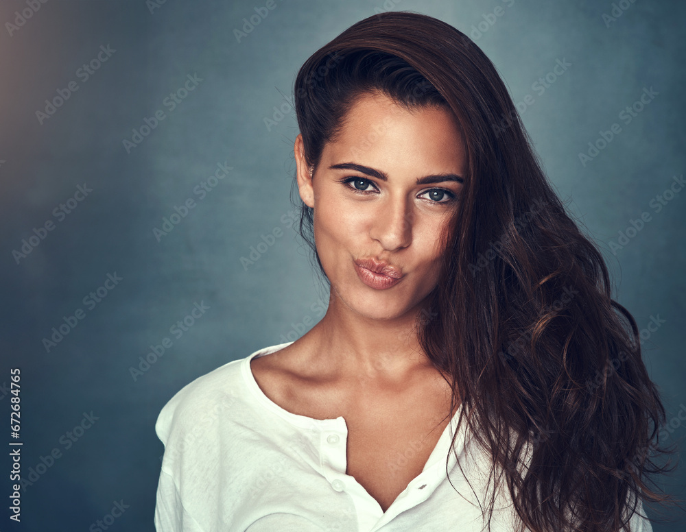 Fototapeta premium Portrait, beauty and lips of a woman in studio on a gray background for natural feminine skincare. Face, hair and cosmetics with a confident young model at the salon or spa for luxury treatment