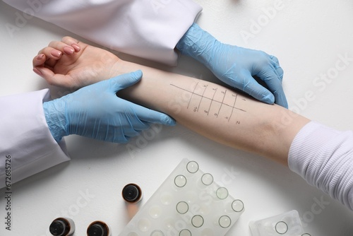 Doctor doing skin allergy test at light table, top view