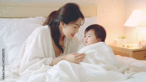 portrait of a beautiful Asian mother and cute child on the bed