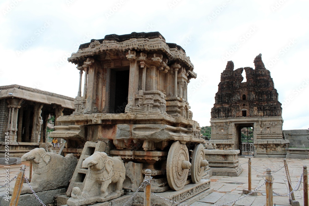 Hampi, Karnataka India - July 24 2023: Stone chariot at temple of Vijaya Vittala complex in desert valley of Hampi