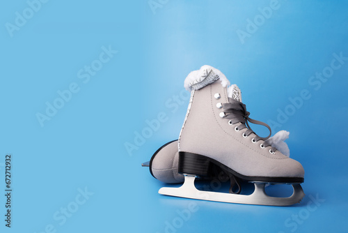 Ice skate boots on a blue background, a winter sport symbol, copy space