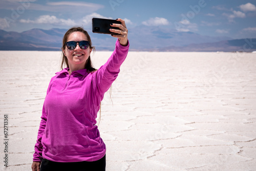 Mujer turista tomándose una selfie en las Salinas Grandes, de la Provincia de Jujuy, Argentina photo