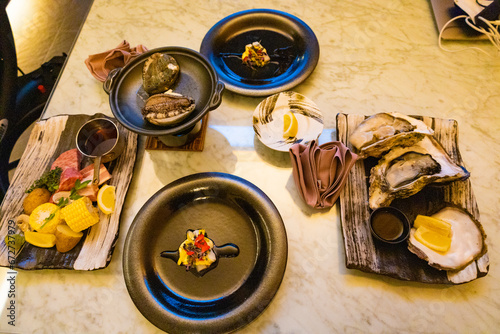 生ガキとアスパラの前菜とグリルステーキと野菜の盛り合わせに白ワインの食卓・ホームパーティ料理