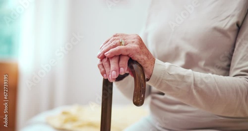 Cane, hands and elderly woman in home in bedroom for retirement in house. Walking stick, bed and closeup of senior person with a disability, stroke and crutch for injury, mobility support or balance photo