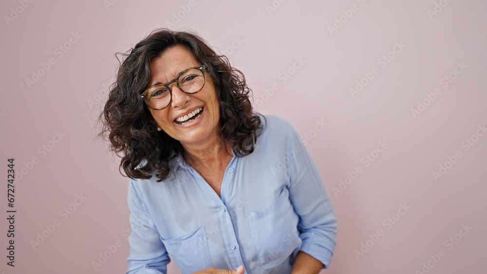 Middle age hispanic woman laughing a lot over isolated pink background Middle age hispanic woman laughing a lot over isolated pink background