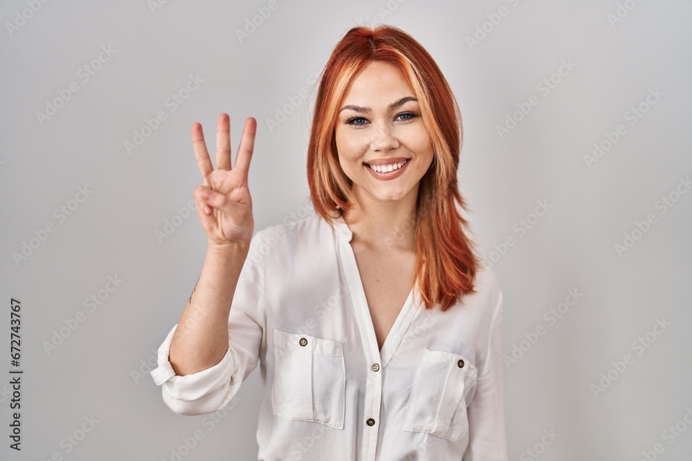 Young caucasian woman standing over isolated background showing and pointing up with fingers number three while smiling confident and happy. Young caucasian woman standing over isolated background showing and pointing up with fingers number three while smiling confident and happy.