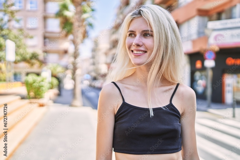 Young blonde woman smiling confident looking to the side at street