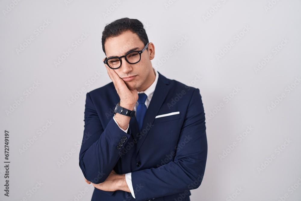 Young hispanic man wearing suit and tie thinking looking tired and bored with depression problems with crossed arms. Young hispanic man wearing suit and tie thinking looking tired and bored with depression problems with crossed arms.