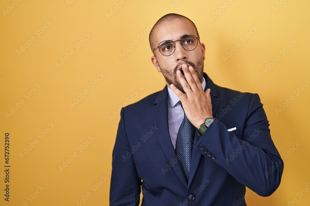 Hispanic man with beard wearing suit and tie bored yawning tired covering mouth with hand. restless and sleepiness. Hispanic man with beard wearing suit and tie bored yawning tired covering mouth with hand. restless and sleepiness.