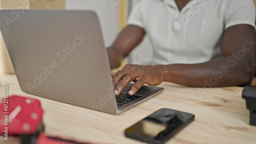 African american man ecommerce business worker typing on laptop at office