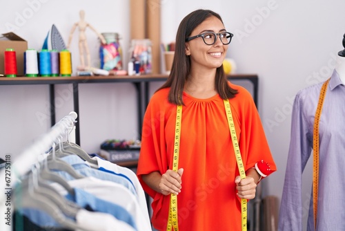 Young beautiful hispanic woman tailor smiling confident standing at tailor shop