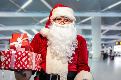 christmas concept at airport holidays with happy santa claus smiling nicely with gifts