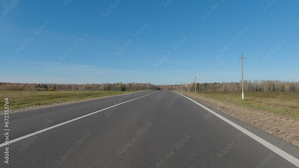 The car drives along the road on a autumn day. Highways, roadside and road line markings. The car drives along the road on a autumn day. Highways, roadside and road line markings.