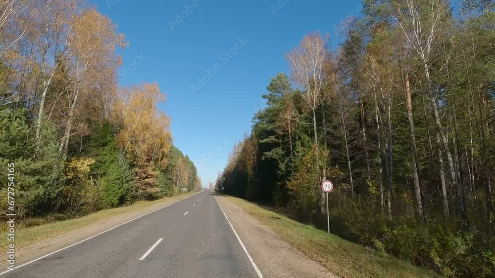 The car drives along the road on a autumn day. Highways, roadside and road line markings. The car drives along the road on a autumn day. Highways, roadside and road line markings.