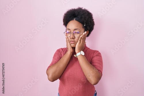 Canvas-taulu Beautiful african woman with curly hair standing over pink background tired hand