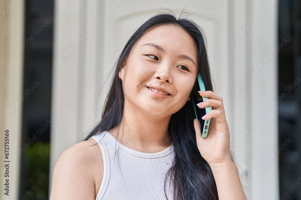 Young chinese woman smiling confident talking on the smartphone at street Young chinese woman smiling confident talking on the smartphone at street