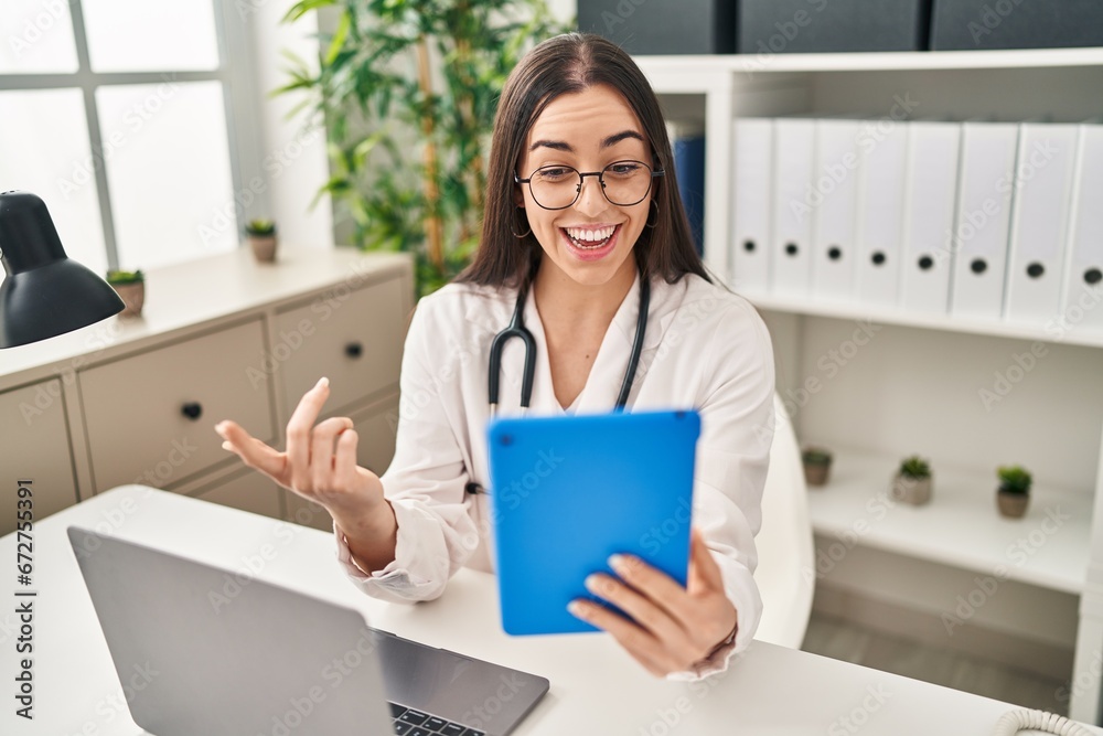 Young beautiful hispanic woman doctor smiling confident having video call at clinic Young beautiful hispanic woman doctor smiling confident having video call at clinic