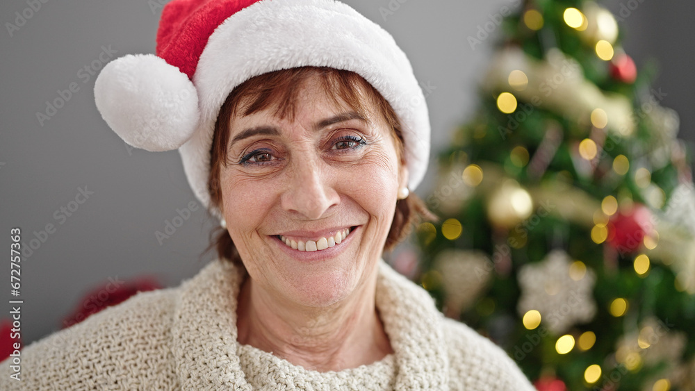 Mature hispanic woman smiling confident standing by christmas tree at home Mature hispanic woman smiling confident standing by christmas tree at home