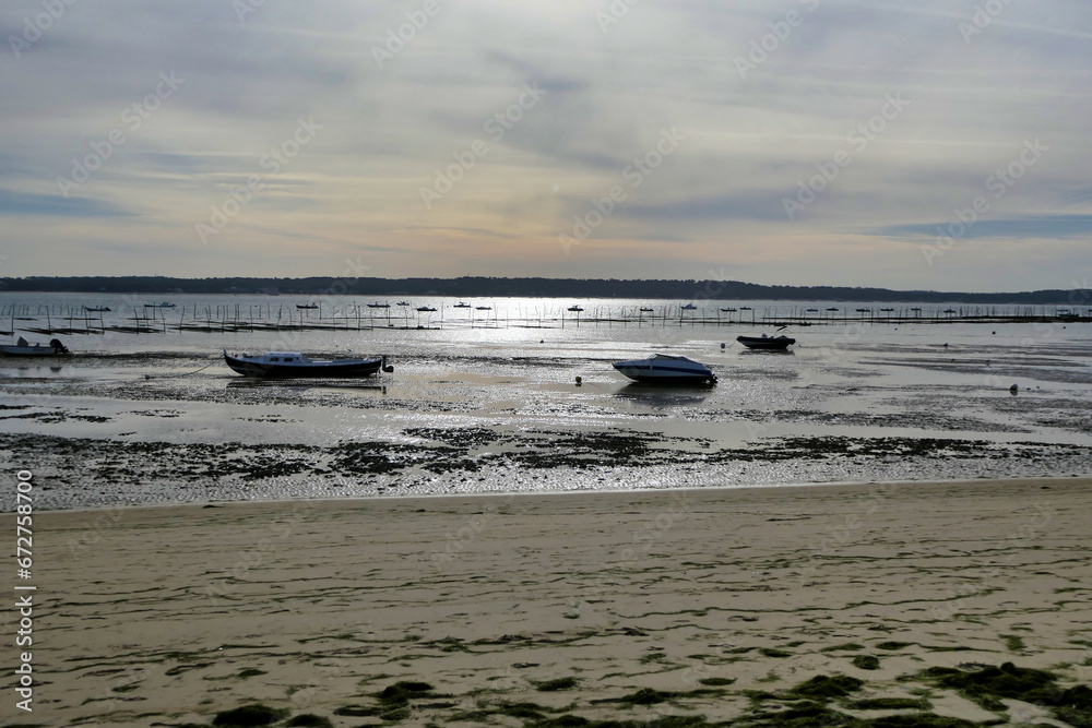 Fototapeta premium Evening on the shoreline at Cap Ferret looking across the Arcachon Bay towards the shoreline of Arcachon, France