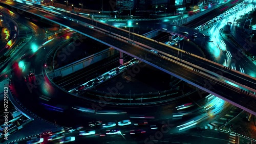Financial technology, energy power, beautiful top view time-lapse of car traffic at roundabout lane and buildings. 4K drone aerial zoom out. Urban cityscape concept or abstract of advanced innovation.
