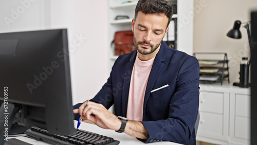 Young hispanic man business worker using computer looking watch at office © Krakenimages.com