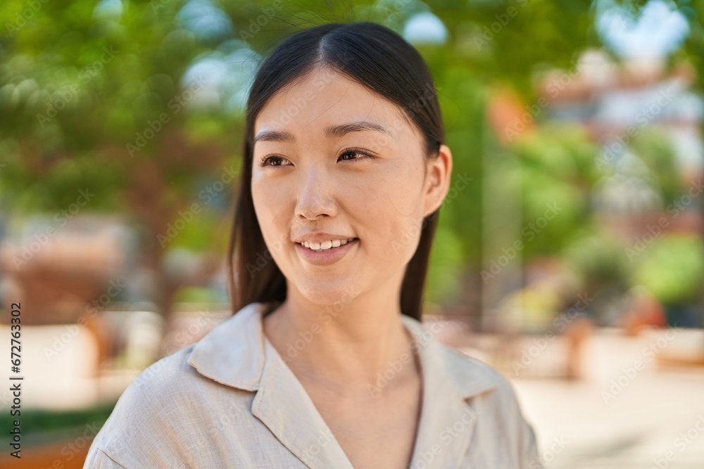 Chinese woman smiling confident looking to the side at park Chinese woman smiling confident looking to the side at park