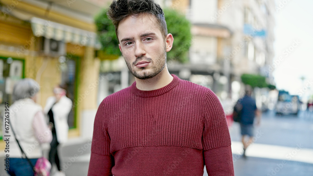 Fototapeta premium Young hispanic man standing with serious expression at street