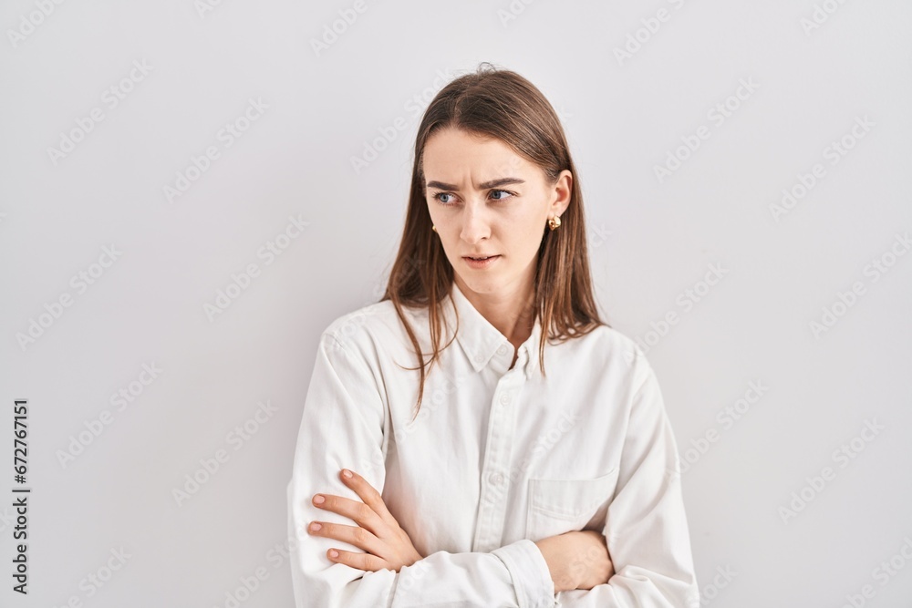 Young caucasian woman standing over isolated background skeptic and nervous, disapproving expression on face with crossed arms. negative person. Young caucasian woman standing over isolated background skeptic and nervous, disapproving expression on face with crossed arms. negative person.