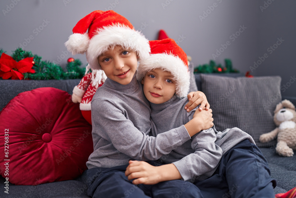 Adorable boys hugging each other celebrating christmas at home Adorable boys hugging each other celebrating christmas at home