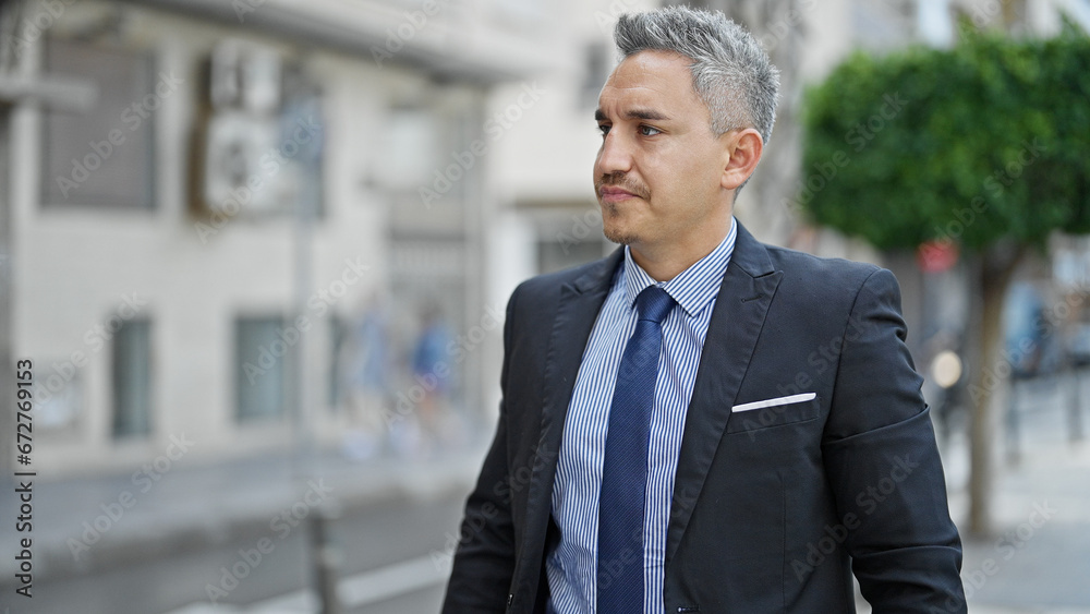 Young hispanic man business worker standing with serious face at street Young hispanic man business worker standing with serious face at street