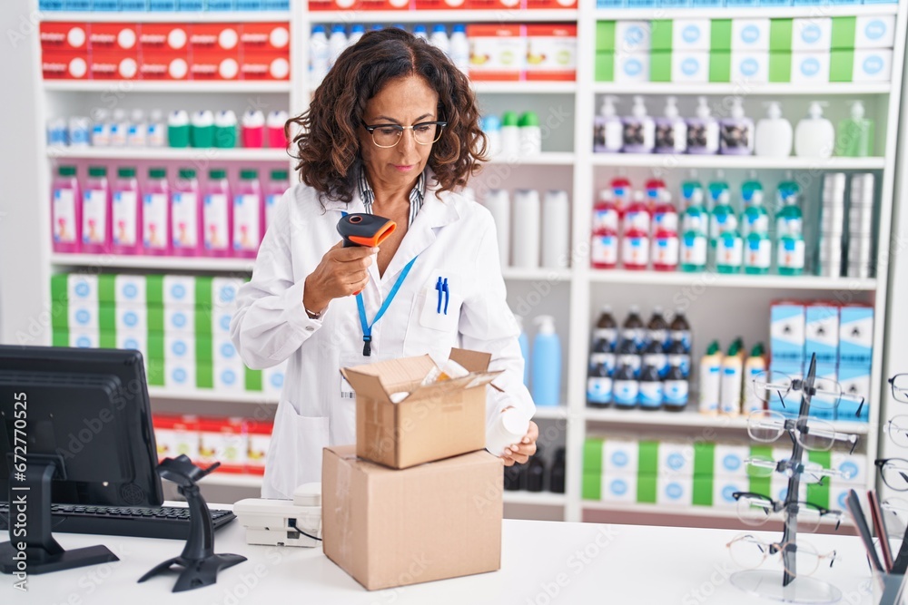Middle age woman pharmacist scanning pills bottle at pharmacy