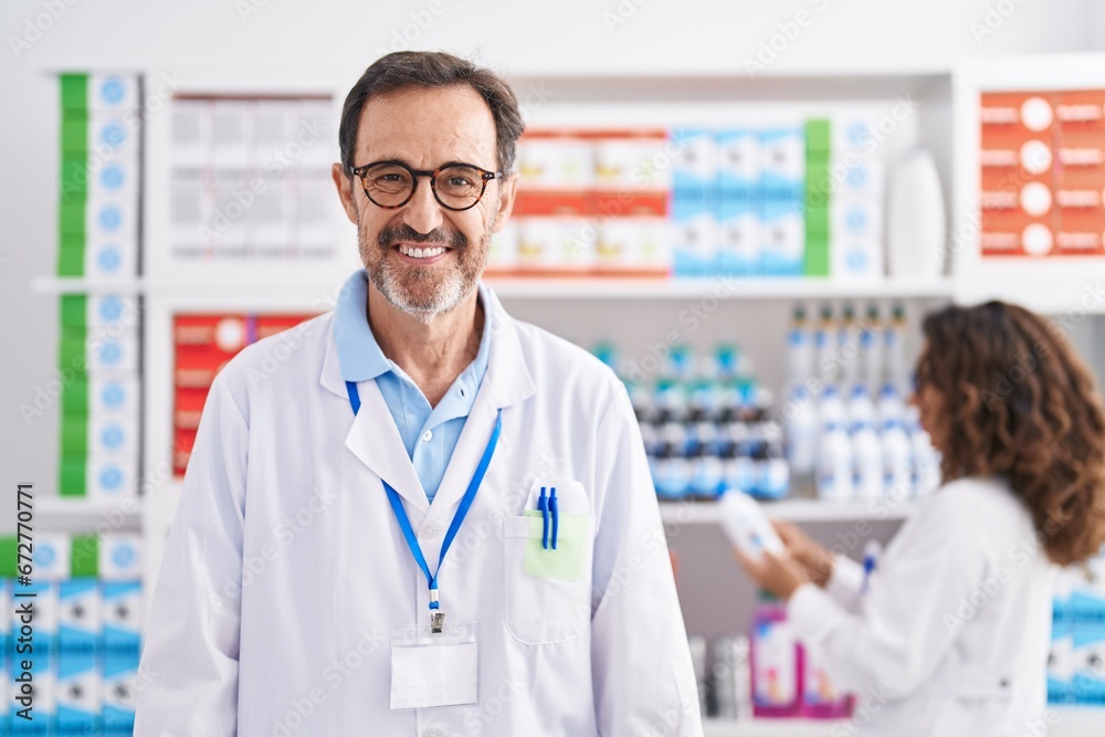 Man and woman pharmacists smiling confident working at pharmacy Man and woman pharmacists smiling confident working at pharmacy