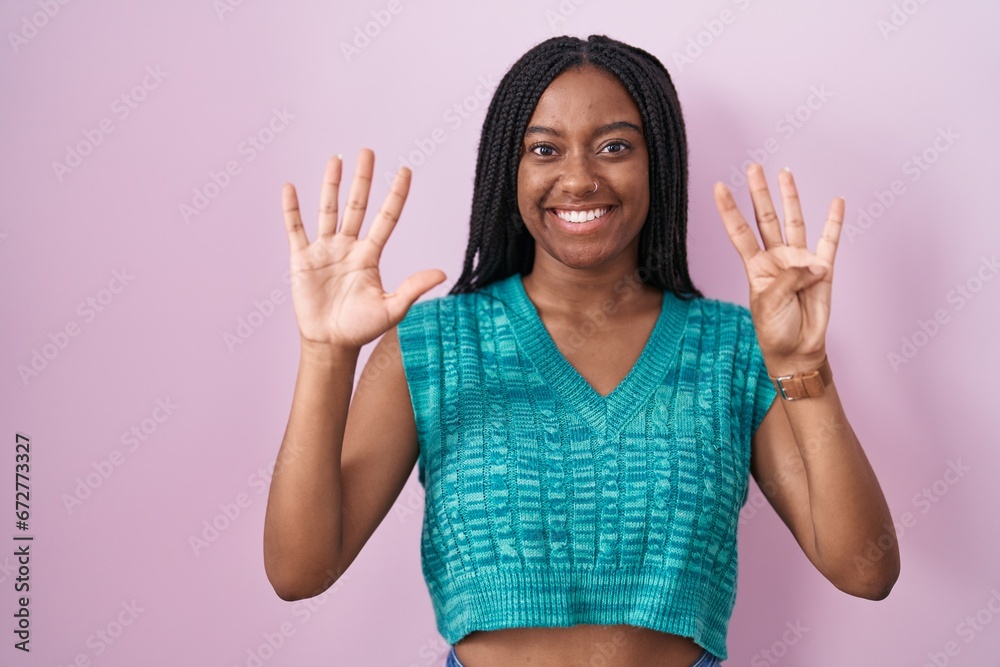 Young african american with braids standing over pink background showing and pointing up with fingers number nine while smiling confident and happy.