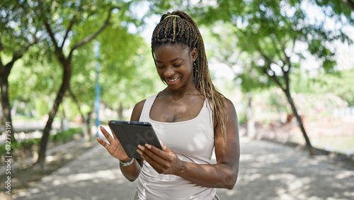 African american woman smiling confident using touchpad at park