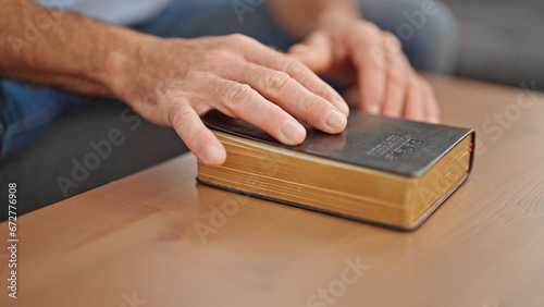 Middle age man touching bible at new home