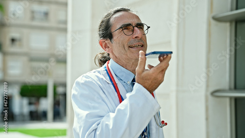 Middle age man doctor sending voice message at hospital © Krakenimages.com
