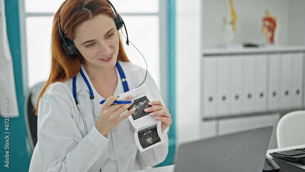 Young redhead woman gynecologist doing video call with laptop holding ultrasound at clinic Young redhead woman gynecologist doing video call with laptop holding ultrasound at clinic