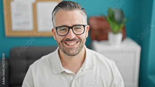 Grey-haired man business worker looking watch smiling at the office
