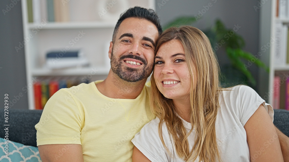 Man and woman couple hugging each other sitting on sofa at home Man and woman couple hugging each other sitting on sofa at home
