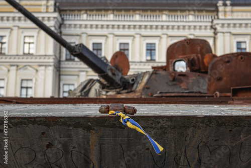 a yellow and blue ribbon is tied on the broken russian equipment